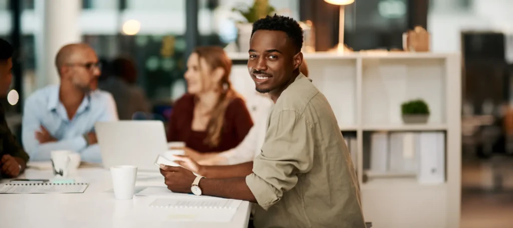 Jeune homme souriant en réunion au bureau