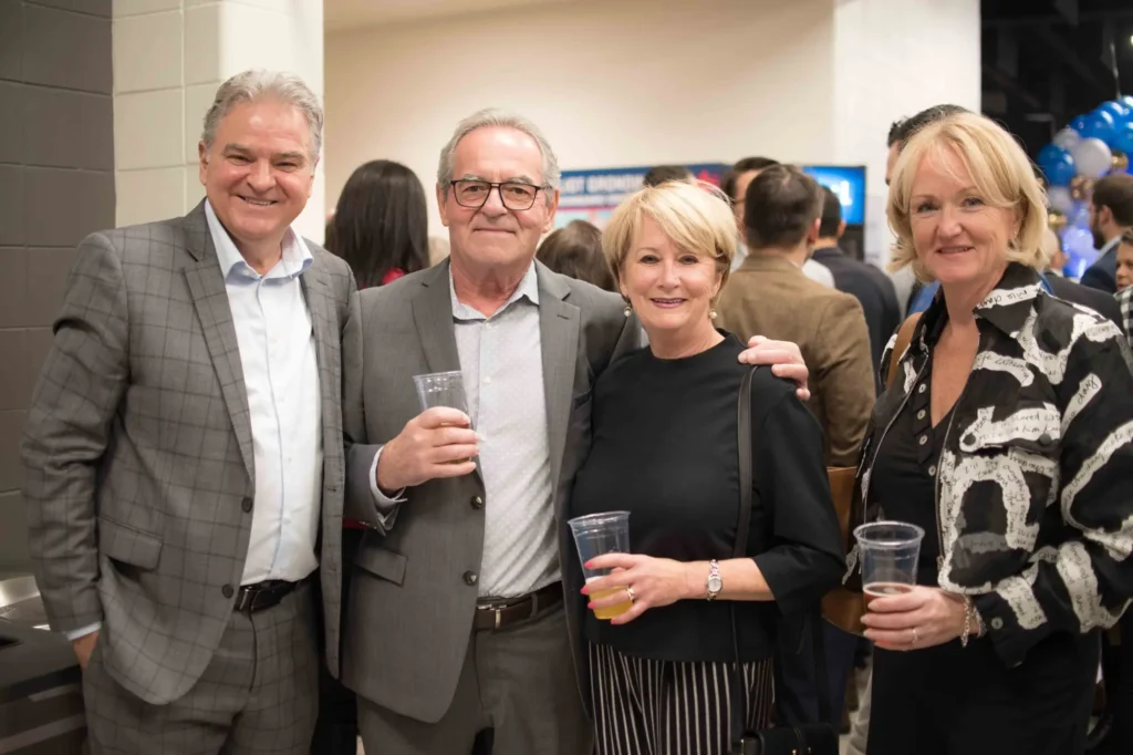 Quatre adultes souriants lors d’un événement convivial