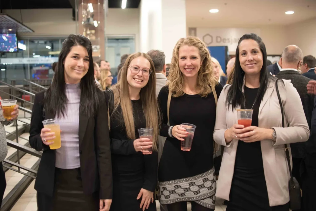Quatre femmes souriantes lors d’un événement professionnel