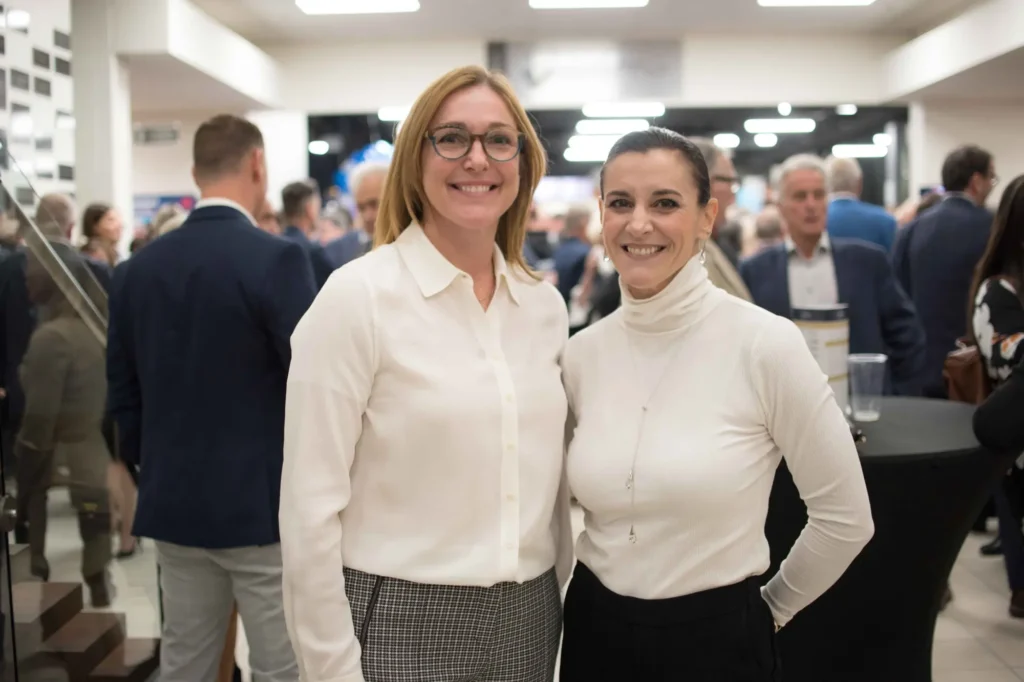 Deux femmes souriantes lors d’un événement professionnel
