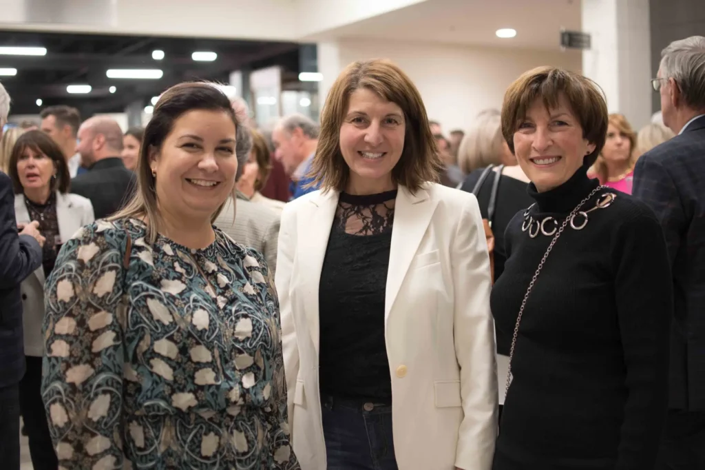 Trois femmes souriantes lors d’un événement professionnel