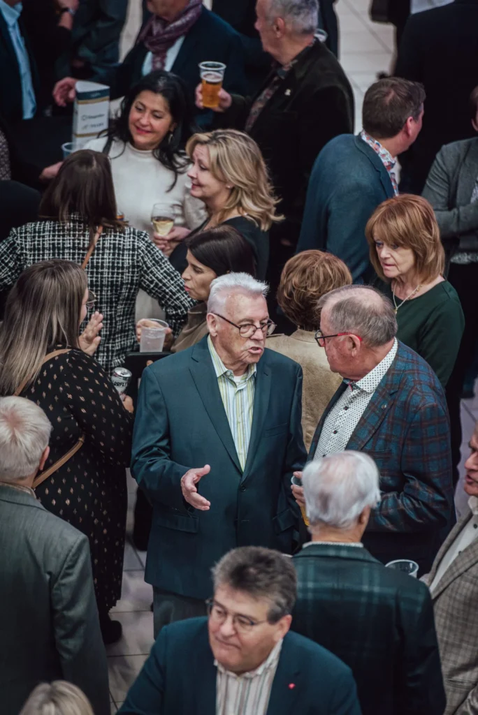 Réception animée avec invités discutant et verres à la main