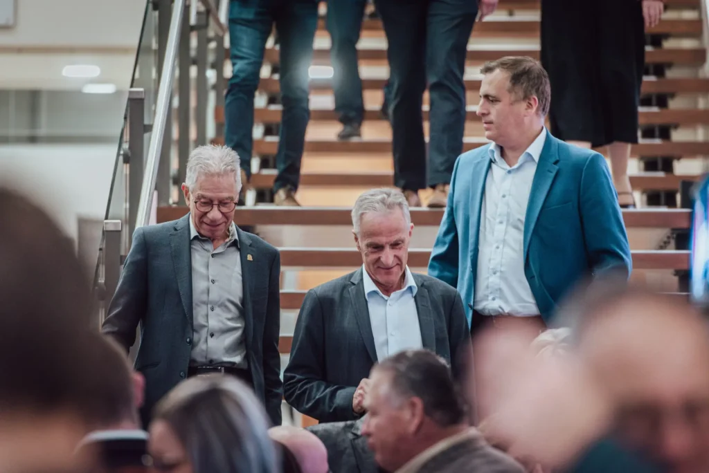 Trois hommes en costume descendant un escalier