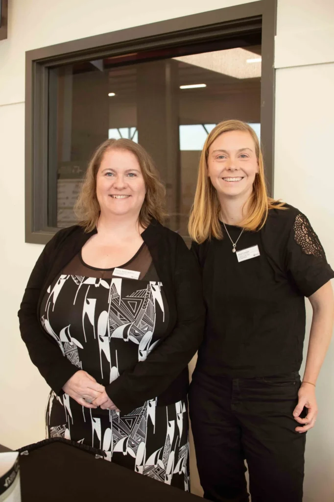 Deux femmes souriantes lors d’un événement professionnel