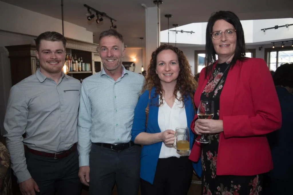 Quatre adultes souriants lors d’un événement convivial