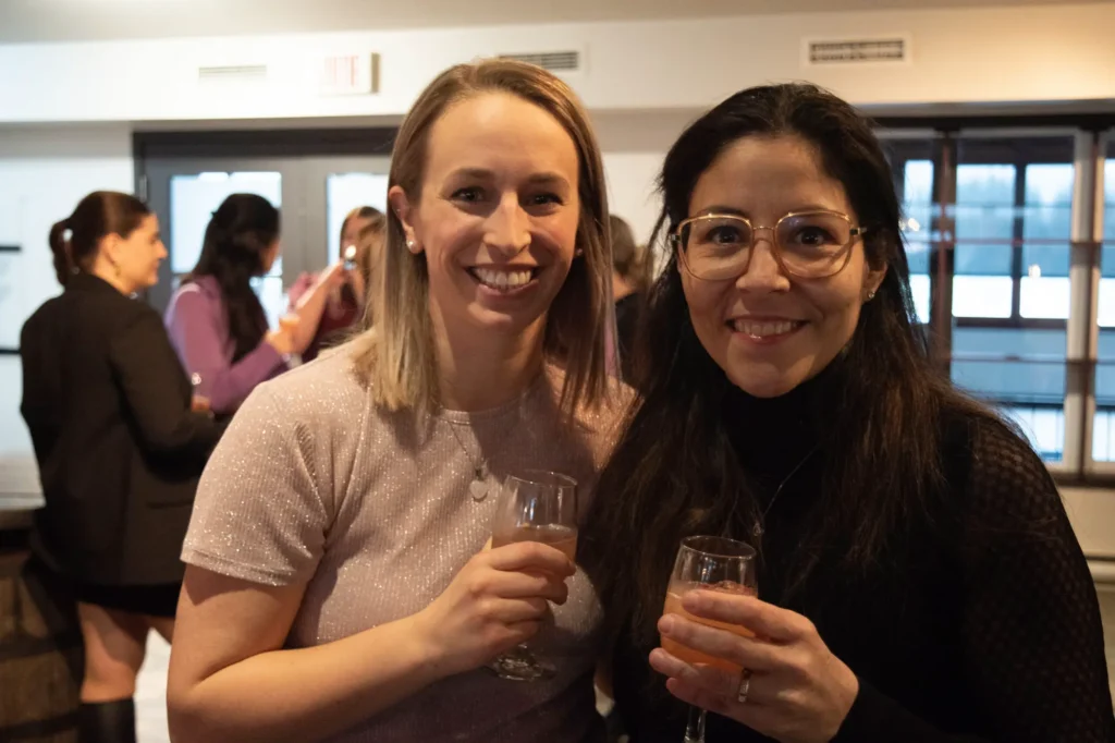 Deux femmes souriantes trinquant lors d’un événement