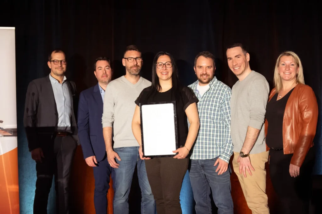 Groupe sur scène avec certificat encadré