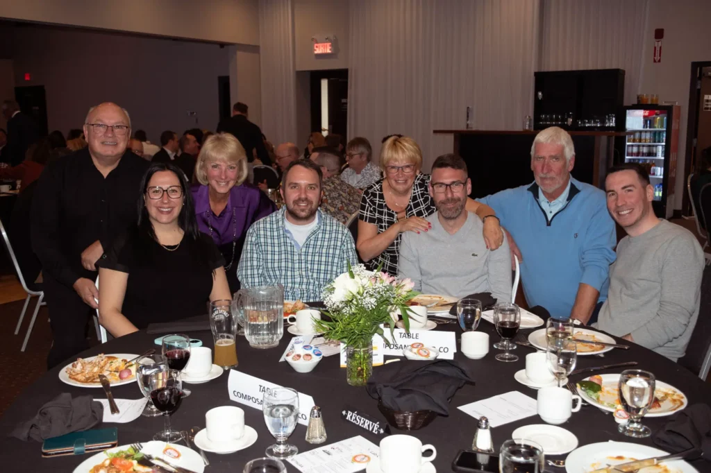 Groupe d’adultes souriants autour d’une table de banquet