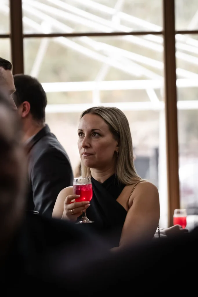 Femme tenant un cocktail rouge lors d’un événement