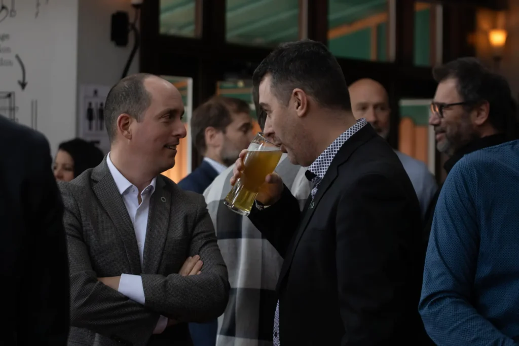 Hommes en costume discutant autour d’une bière