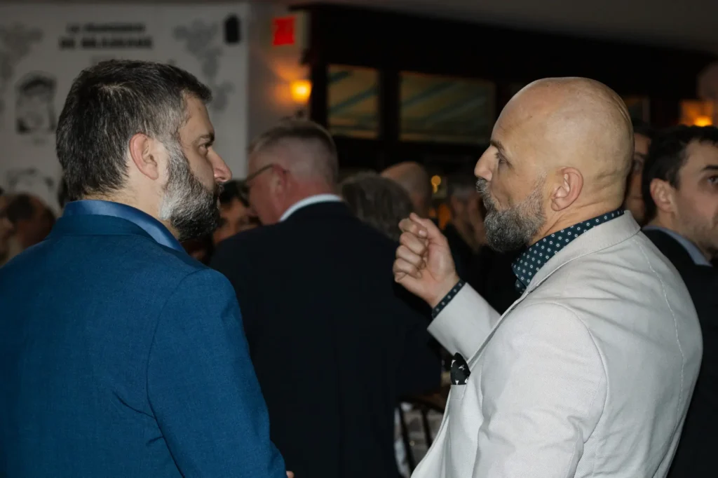Deux hommes en costume discutant lors d’un événement