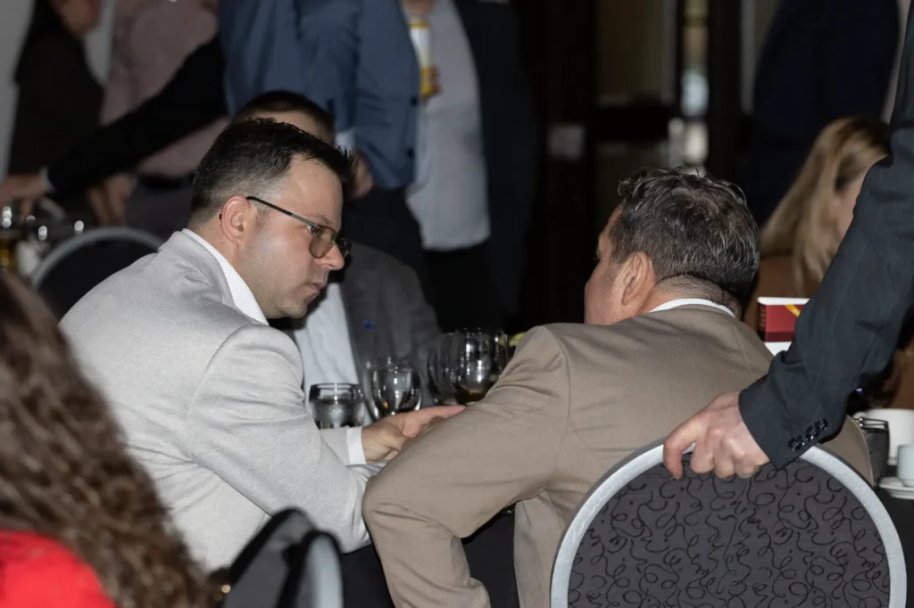 Deux hommes en costume discutent à table