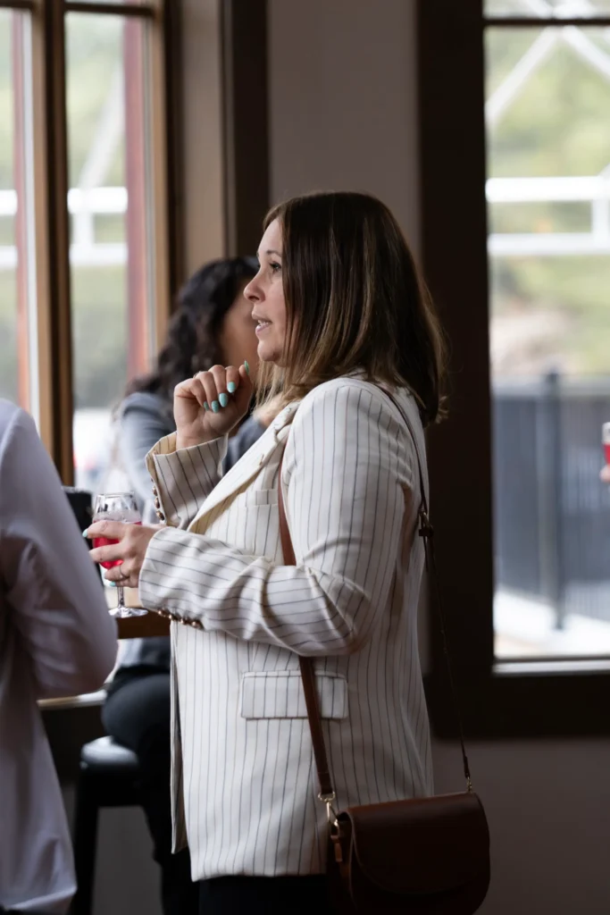 Femme en blazer discutant avec un verre