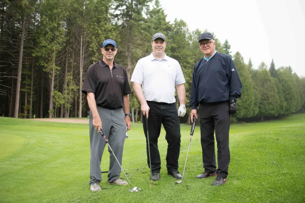 Trois golfeurs posant sur un green