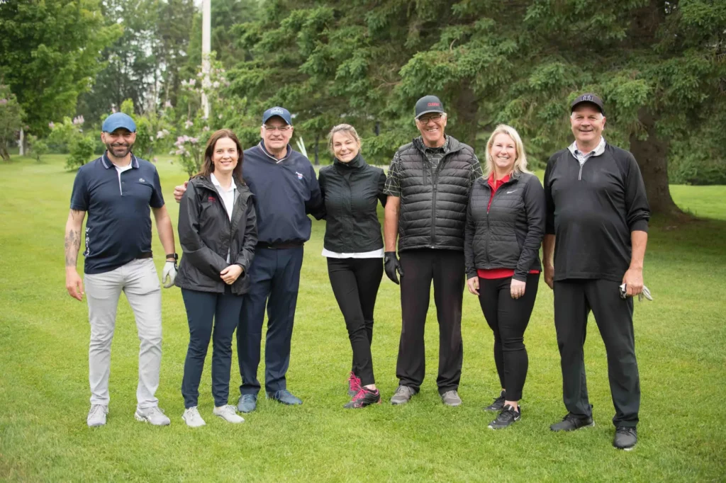 Groupe d’adultes souriants sur un parcours de golf