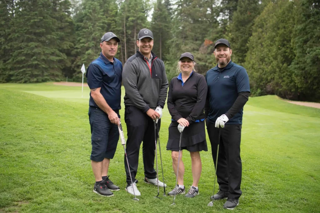 Quatre golfeurs posant sur un green