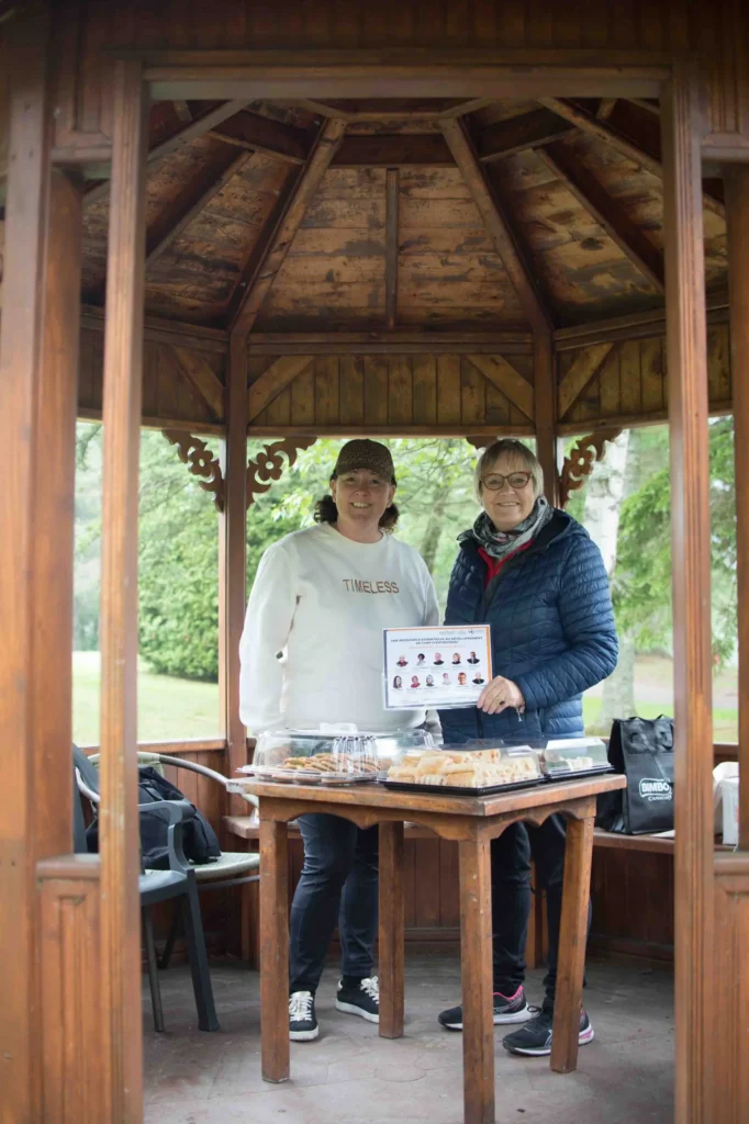 Deux femmes dans un kiosque tenant un certificat