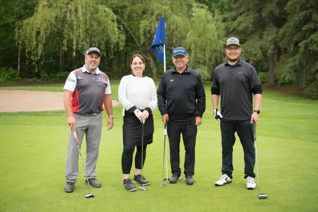 Quatre golfeurs posant sur un green