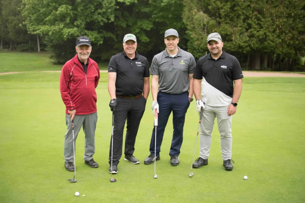 Quatre golfeurs posant sur un green