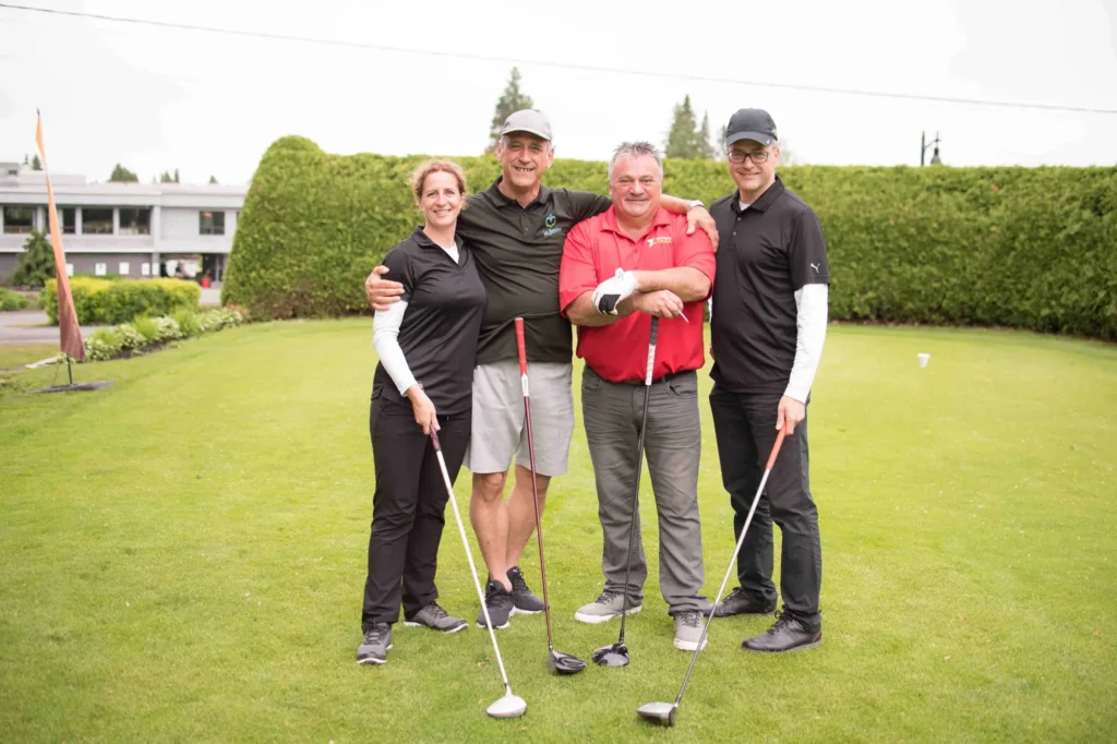 Quatre golfeurs souriants sur un green