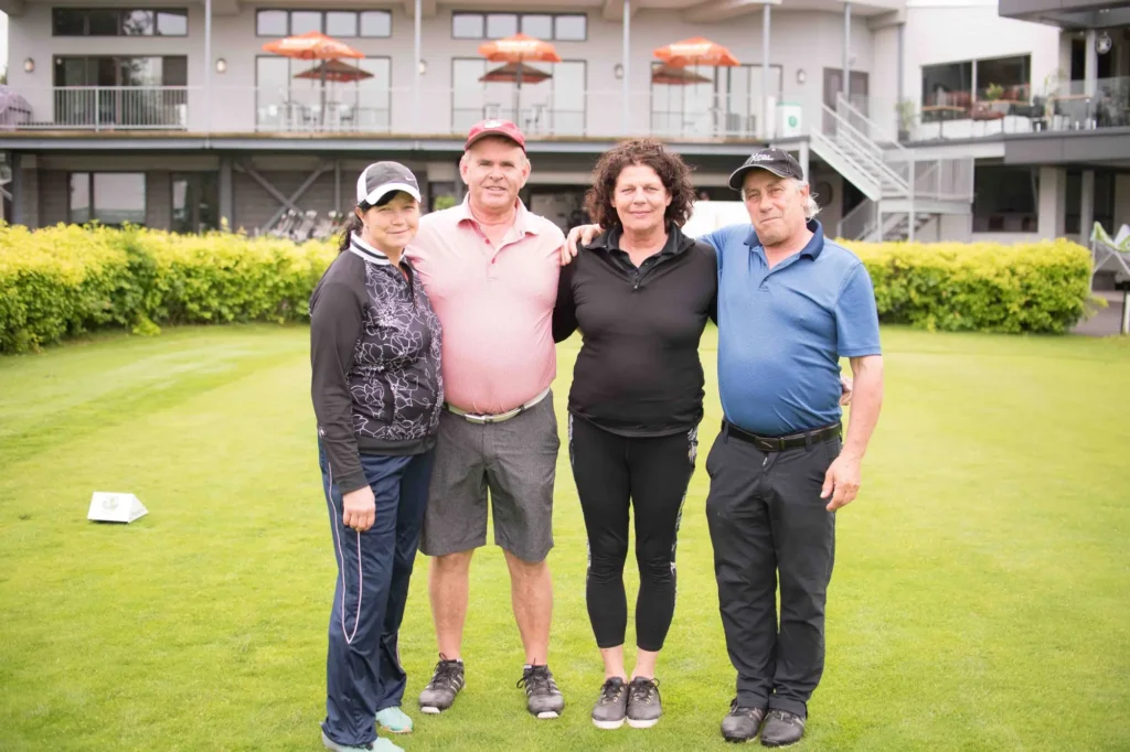 Quatre golfeurs posent sur un green