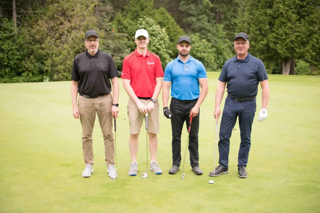 Quatre golfeurs posant sur un green