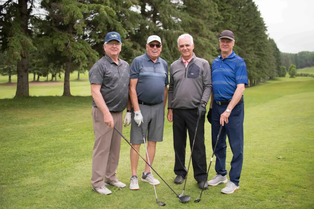 Quatre hommes jouant au golf sur un parcours