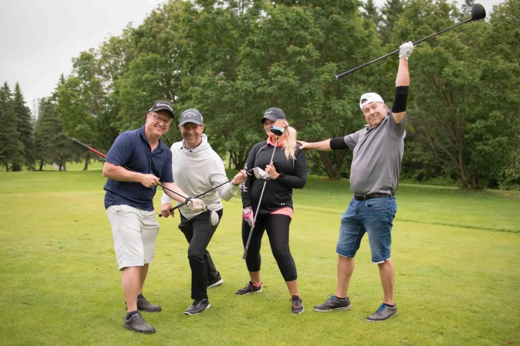 Quatre amis posant sur un parcours de golf