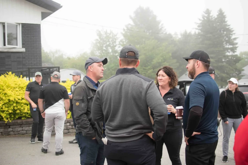 Groupe d’adultes discutant devant un clubhouse brumeux