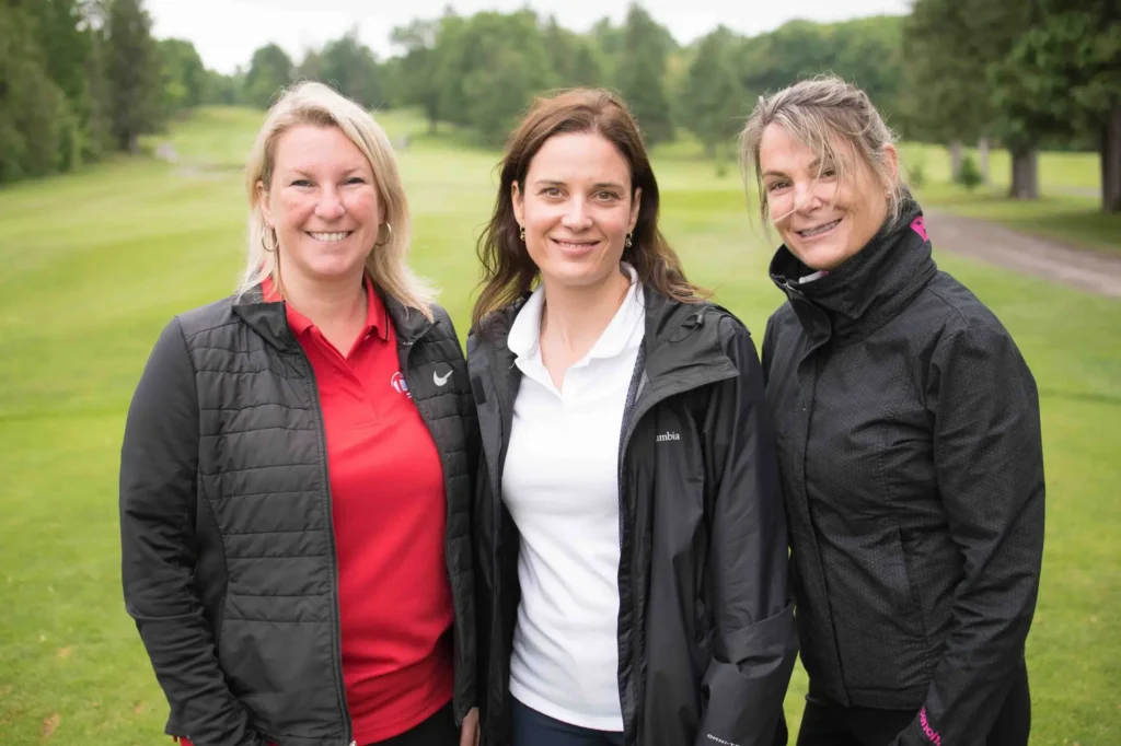 Trois femmes souriantes sur un parcours de golf