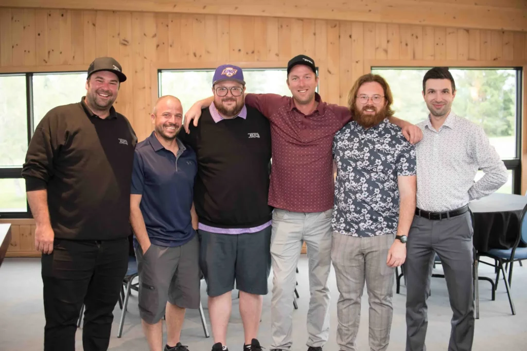 Six hommes souriants posant bras dessus bras dessous