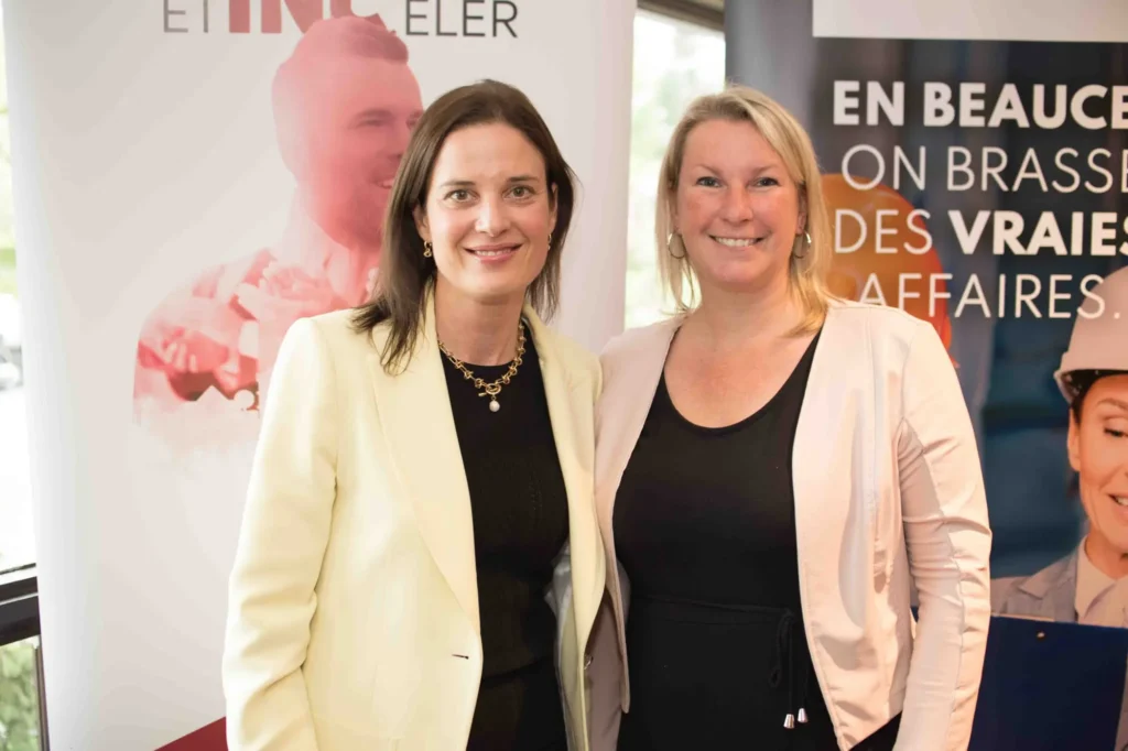Deux femmes souriantes lors d’un événement professionnel