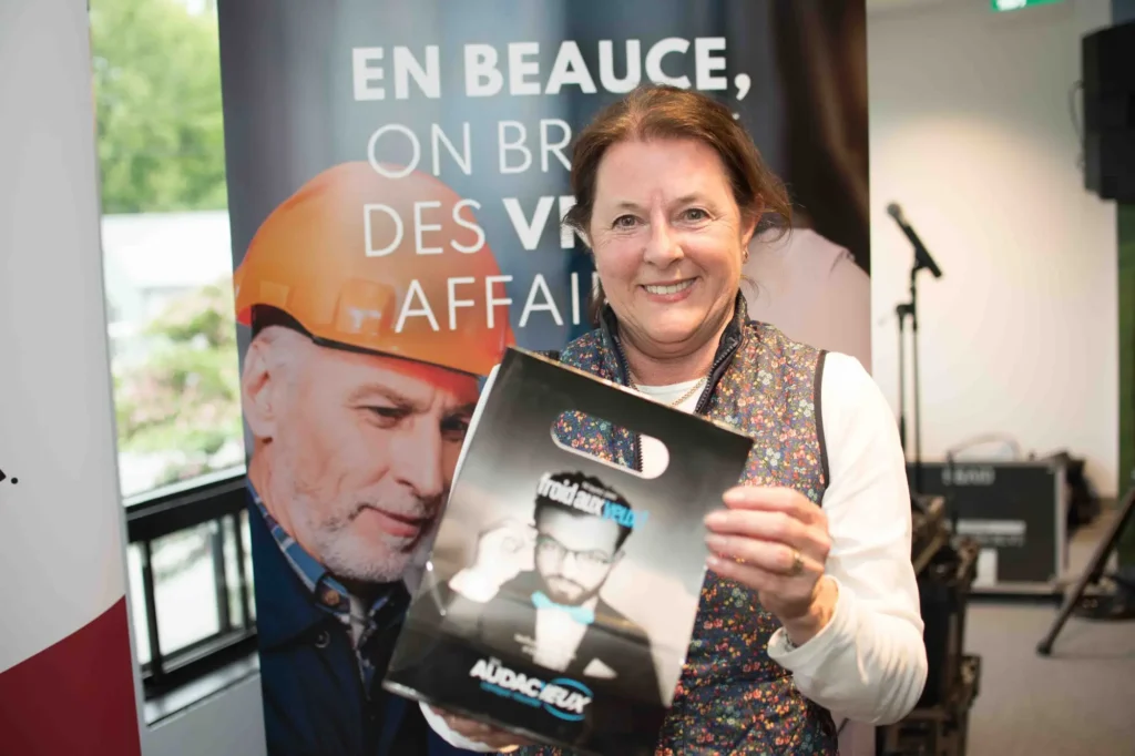 Femme souriante tenant un magazine lors d’un événement