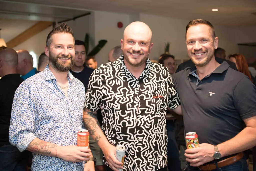 Trois hommes souriants lors d’une soirée conviviale