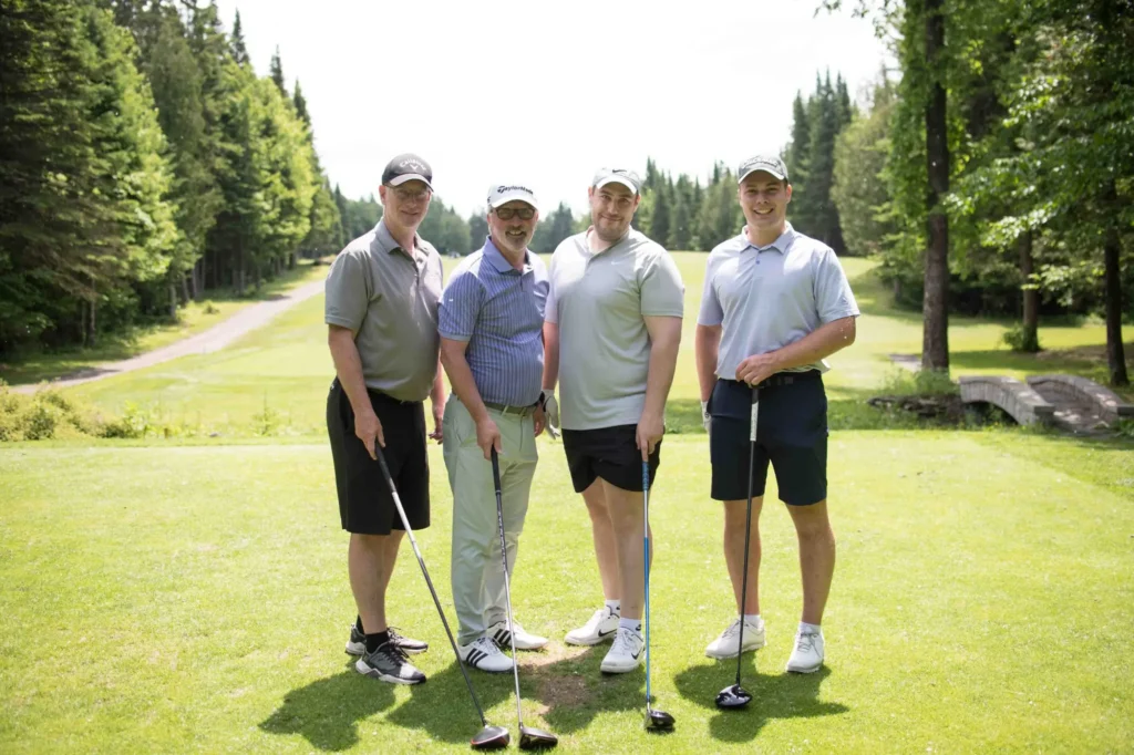 Quatre hommes posant sur un parcours de golf