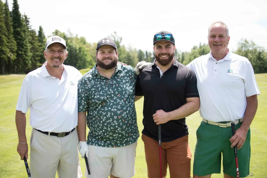 Quatre hommes posant sur un parcours de golf