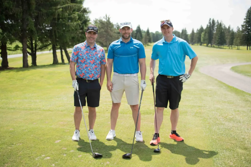 Trois golfeurs posant sur un parcours ensoleillé