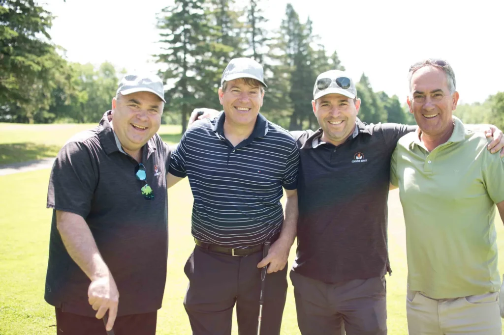 Quatre amis souriants sur un parcours de golf