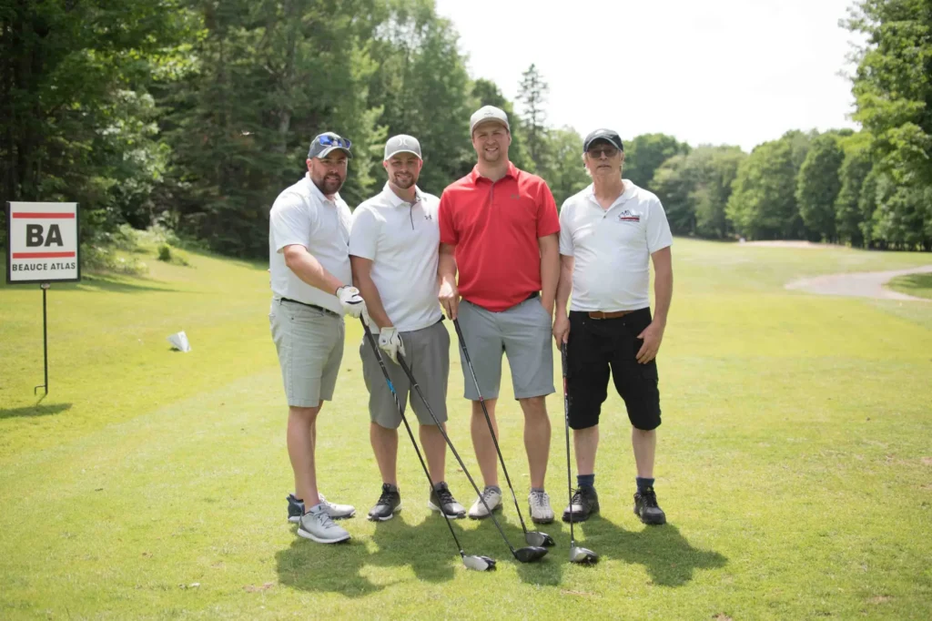Quatre golfeurs posant sur un parcours ensoleillé