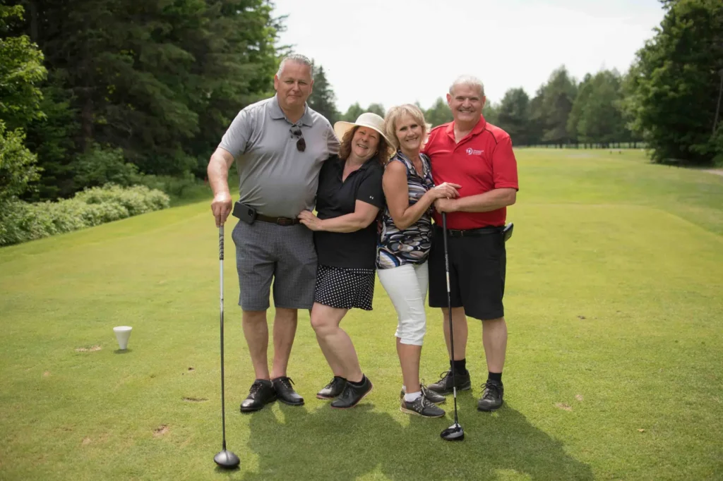 Quatre amis posent sur un parcours de golf