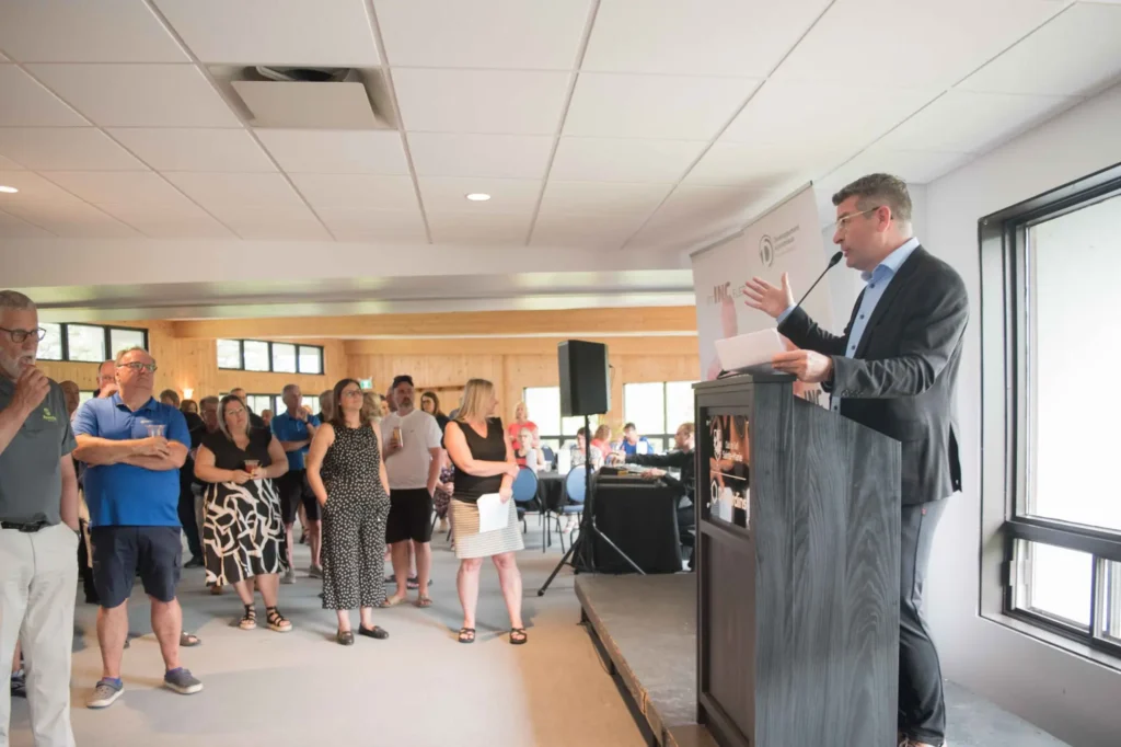 Discours d’un homme en costume devant un public