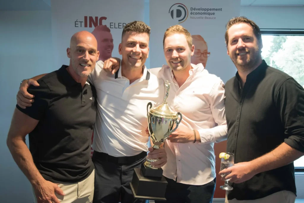Quatre hommes souriants avec un trophée