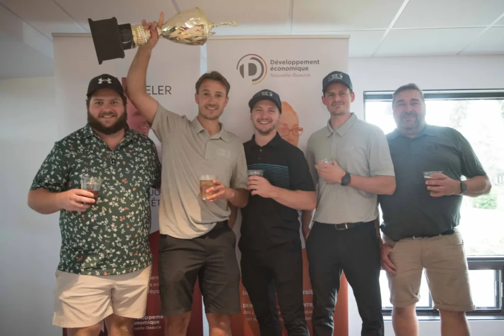 Cinq hommes célèbrent avec un trophée