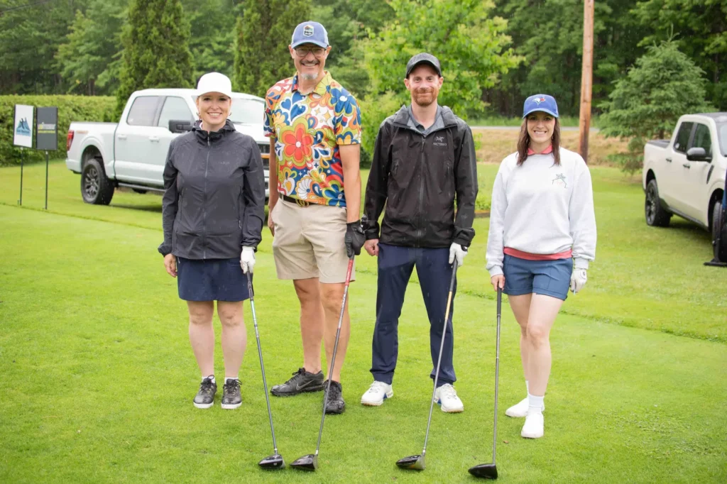 Quatre golfeurs posant sur un green