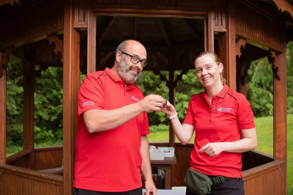 Deux collègues en polos rouges sous un kiosque