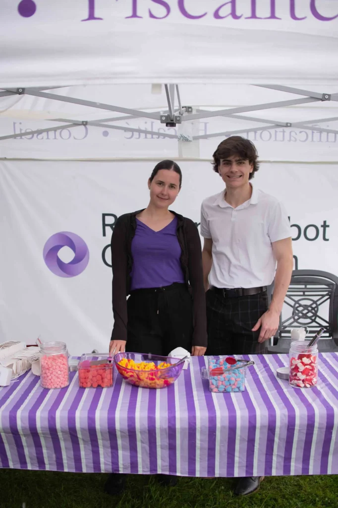 Deux personnes derrière un stand de bonbons