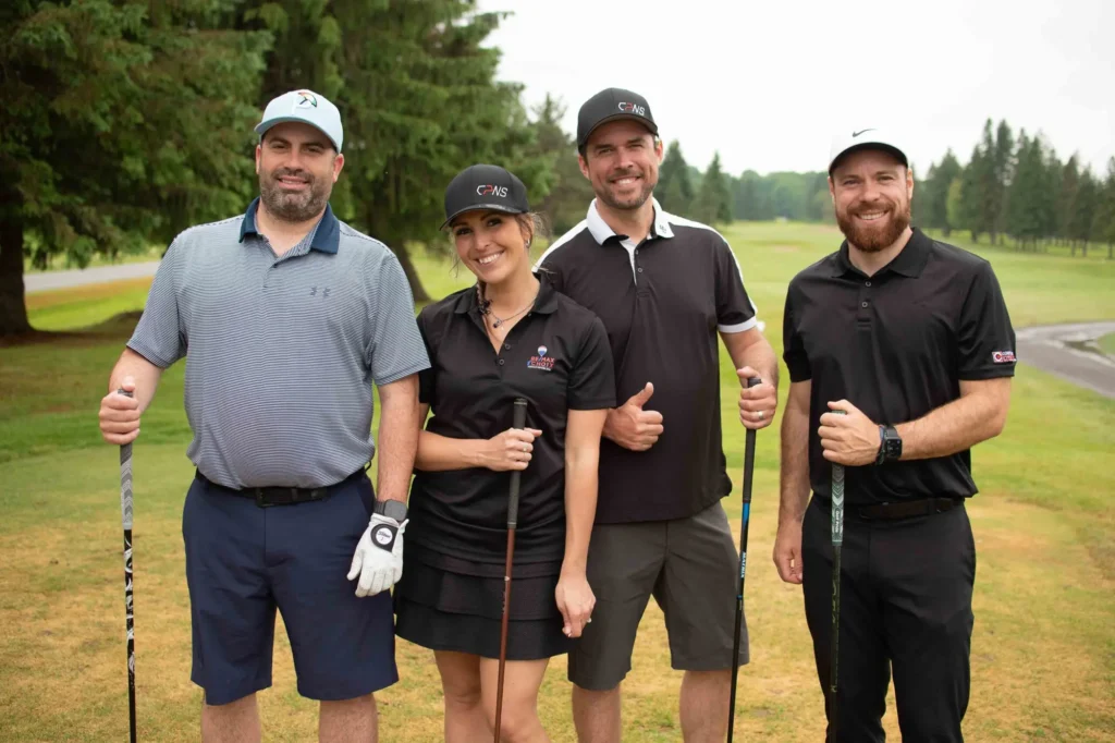 Quatre golfeurs souriants sur un parcours verdoyant