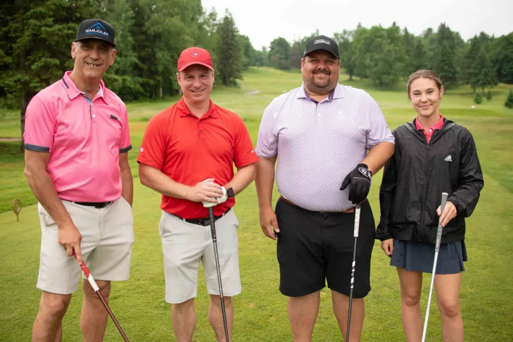 Quatre golfeurs posant sur un parcours verdoyant