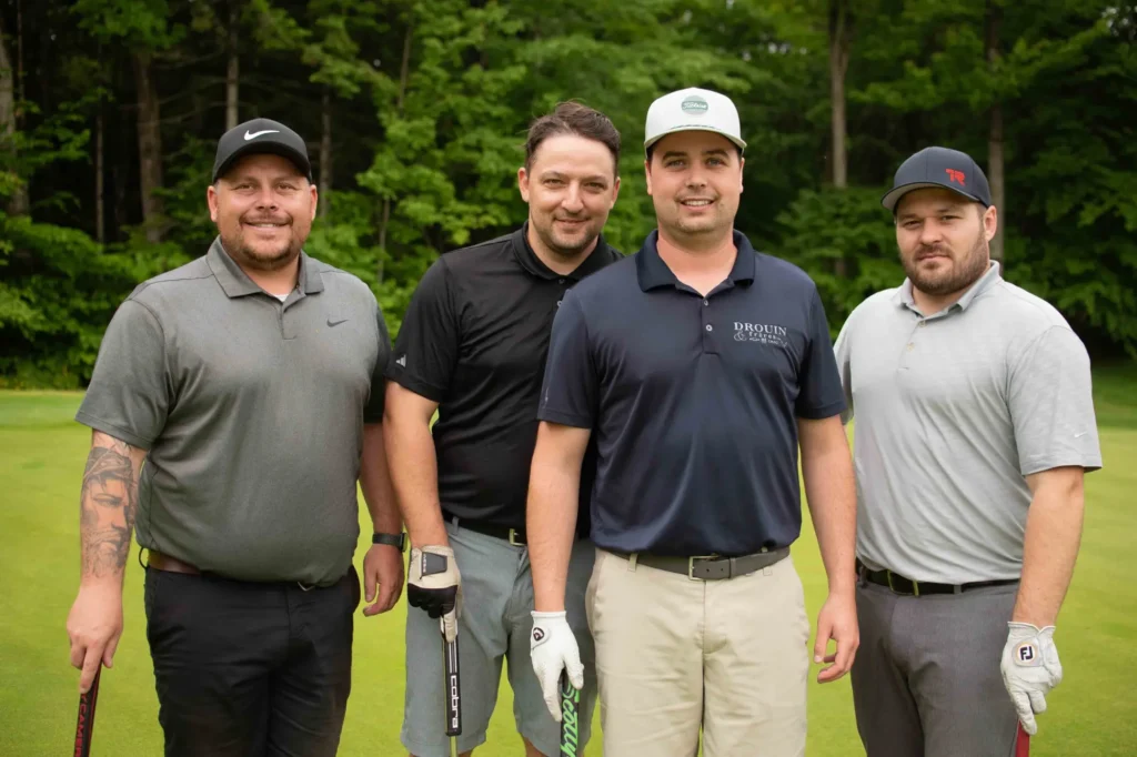 Quatre golfeurs posant sur un parcours verdoyant