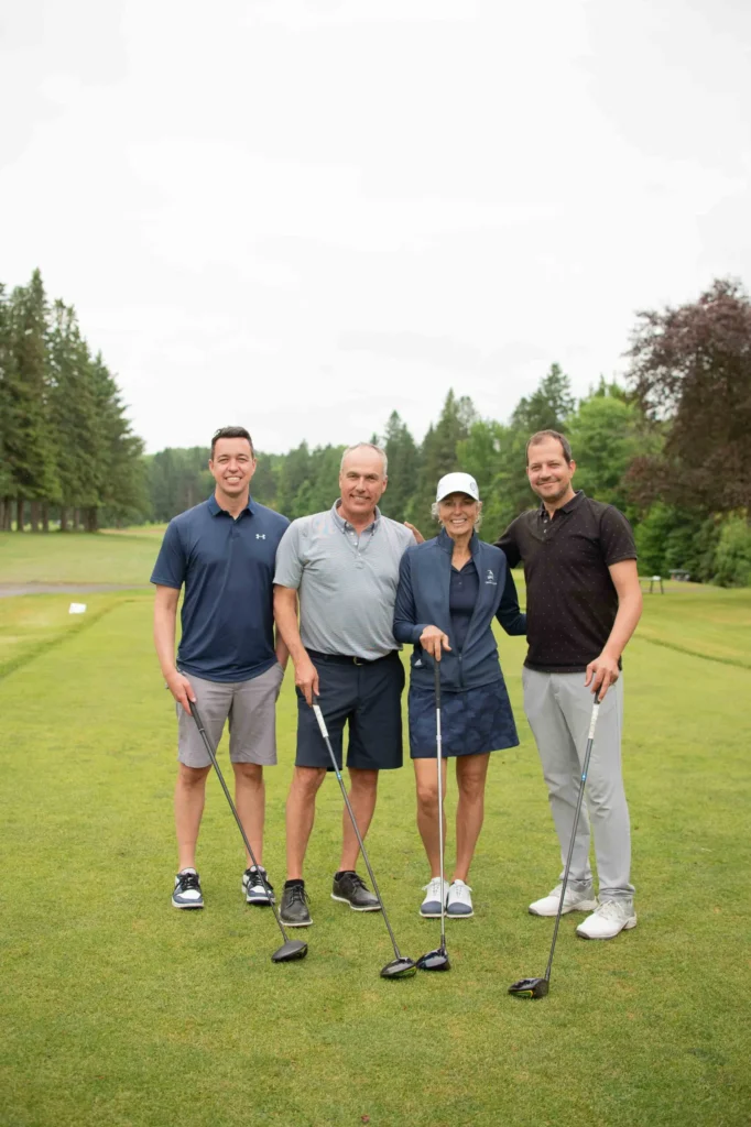 Quatre golfeurs souriants sur un parcours verdoyant